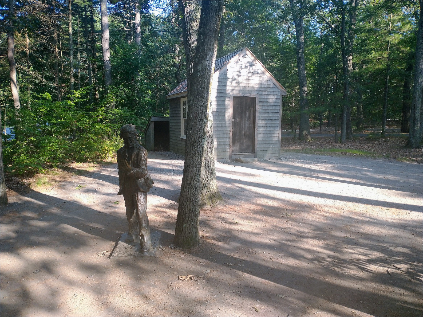 Statue of Thoreau by a replica of his cabin on Walden Pond